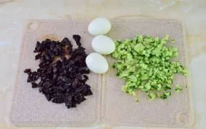 Nulupkite kiaušinius. Smulkiai supjaustykite slyvas ir agurką.