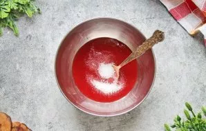 Į braškių tyrę įberkite cukraus ir maišykite, kol ištirps.
