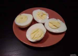 Tuo metu kiaušinius išvirkite. Tada perpjaukite juos per pusę.