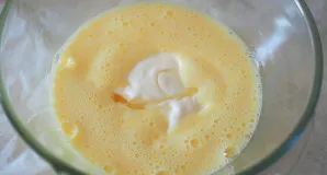 Kiaušinius išplakite su cukrumi į šviesią, purią masę, naudojant plakiklį arba mikserį. Įmaišykite grietinę ir saulėgrąžų aliejų, atsargi...