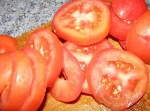 Supjaustykite pomidorus plonais griežinėliais.