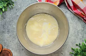 Supilkite į masę šaltą pieną ir išmaišykite iki vientisos konsistencijos. Šaltas pienas atvėsins masę ir padarys ją tinkamą minkymui.