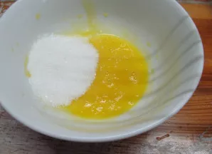 Kiaušinių trynius sumaišykite su cukrumi.