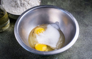 Į atskirą dubenį įmuškite kiaušinius, suberkite visą cukrų ir druską.