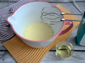 Supilkite į kiaušinių masę augalinį aliejų ir vėl išplakite.