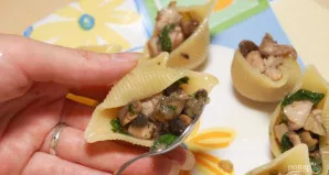 Išvirtus makaronus nuplaukite ir atvėsinkite. Sumaišykite juos su nedideliu kiekiu sviesto. Į kriaukles sudėkite įdarą iš pirmo žingsnio.