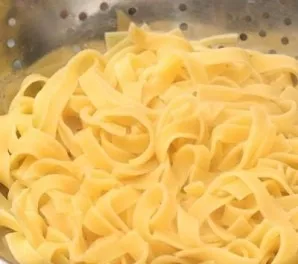 Tagliatelle (makaronus) išvirkite lengvai pasūdytame vandenyje ir nusausinkite vandenį kiaurasamčiu. Į dubenį sudėkite virtus makaronus.