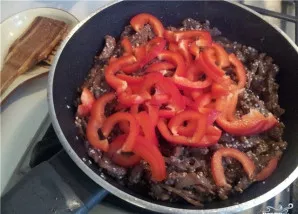 Tada dedame supjaustytą papriką. Kepame viską kartu kelias minutes.