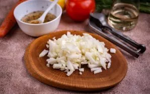 Smulkiai supjaustykite svogūną.