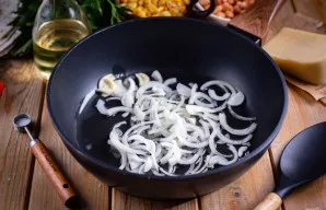 Keptuvėje įkaitinkite augalinį aliejų, sudėkite svogūnų pusžiedžius ir česnaką - kepinkite ant stiprios ugnies, maišydami mentele, apie 4...