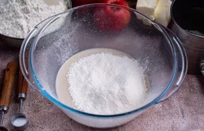 Į mielių mišinį persijokite 100 gramų miltų.