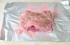 Tada sudėkite džiovintą baziliką ir papriką. Įtrinkite mėsą visais prieskoniais.
