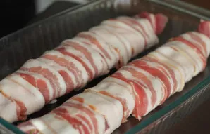 Šoninės juostelėmis atsargiai apvyniokite mėsą, kad sutvirtintumėte sujungimus. Jei norite, kiaulienos vyniotinį galite papildomai sutvir...