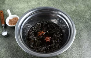 Į dubenį supilkite sojų padažą, įpilkite vandens, suberkite juodąją lapinę arbatą ir žvaigždinį anyžių.