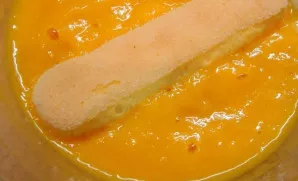 Mangą nulupkite ir trintuvu sutrinkite iki tyrės. Tuomet dvi biskvitinių sausainių lazdelės pamirkykite mangų tyrėje.