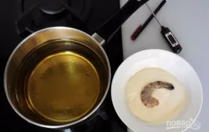 Kiekvieną krevetę apvoliokite tešloje. Įkaitinkite aliejų iki 180 °C gruzdintuvėje arba keptuvėje. Kepkite jūros gėrybes iki auksinės spa...