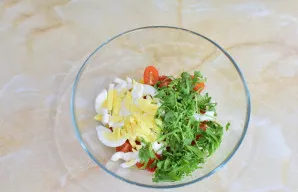 Įdėkite supjaustytus virtus kiaušinius ir smulkintą rukolą.