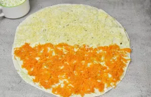 Ant viršaus, ant žuvies, uždėkite antrą lavašą, patepkite jį dalimi padažo, paskirstydami plonu sluoksniu. Ant vienos pusės išdėliokite s...