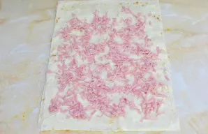 Dešrą galite smulkiai supjaustyti arba sutarkuoti. Tuomet dėkite dešrą ant lavašo.