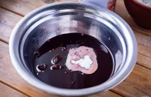 Į kitą dubenį supilkite uogienę ir pridėkite sodą. Išmaišykite šluotele.