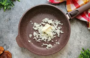 Svogūną smulkiai supjaustykite. Į keptuvę sudėkite sviestą ir svogūną, kepinkite ant vidutinės ugnies 5-6 minutes, kol suminkštės.