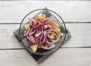 Svogūną nulupkite, supjaustykite pusžiedžiais ir sudėkite į lėkštę.