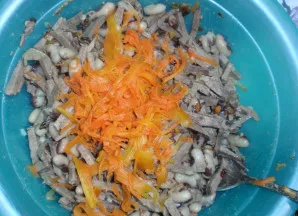 Į mišrainę stambia tarka sutarkuojame virtą morką. Viską pasūdome, pabarstome pipirais ir gerai išmaišome.