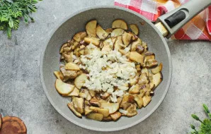 Svogūną smulkiai supjaustykite ir suberkite į keptuvę. Kepkite dar 5-6 minutes ant vidutinės ugnies, atsargiai maišydami.