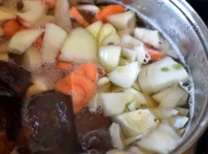 Įdėkite morką ir svogūną, pasūdykite ir virkite iki daržovių minkštumo.