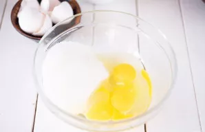 Atskirame inde įmuškite kiaušinius ir įberkite visą cukrų.