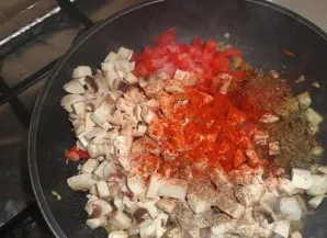 Sudėkite grybus, cukinijas, pomidorus ir smulkintą česnaką. Pagardinkite druska ir prieskoniais ir troškinkite 10 minučių.