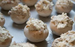 Įdarykite grybo kepurėles paruoštu įdaru, sudėkite jas ant kepimo skardos ir kepkite iki 200 °C įkaitintoje orkaitėje 12-15 minučių.