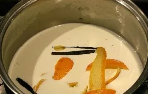 Supilkite pieną ir grietinėlę į puodą. Įdėkite vanilės (taip pat galite naudoti vanilės ankštį, kurią naudojote tešlai) ir apelsino žieve...