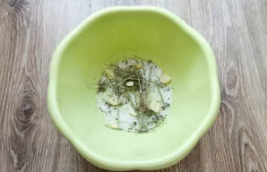 Į dubens dugną įberkite šiek tiek druskos, sudėkite pusę krapų ir pusę nulupto česnako.