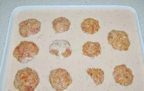 Paruoškime padažą. Sumaišykite grietinėlę, kečupą, vandenį ir miltus. Įberkite druskos ir pipirų. Užpilkite padažą ant kotletų.