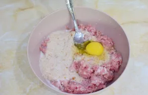 Dubenyje sumaišykite maltą mėsą ir sutrintą batoną. Įmuškite kiaušinį.