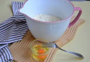 Geriausia vandenį, kiaušinį ir druską išplakti iki vientisos masės ir supilti į miltų mišinį.