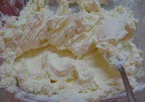 Maskarponę sutrinkite šakute, tada į ją įmaišykite išplaktus trynius. Palaipsniui įmaišykite ir baltymus. Plakite mažesniu greičiu.