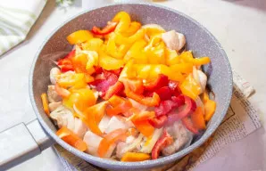 Saldžiąją papriką išvalykite. Minkštimą supjaustykite plonomis juostelėmis ir sudėkite į keptuvę. Kepkite porą minučių.