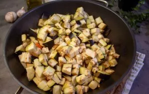 Baklažanus nuplaukite ir nusausinkite, supjaustykite mažais kubeliais ir sudėkite į puodą su daržovėmis. Troškinkite maišydami apie 5 min...