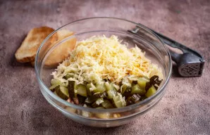 Pridėkite agurkų kubelius ir smulkiai sutarkuotą sūrį, per spaustuką išspauskite česnako skilteles.