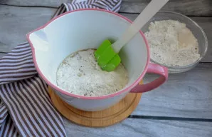 Po truputį maišykite miltus su skystais ingredientais.