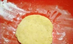 Nuspauskite maždaug 75 gramų dydžio bulvių tešlos gabalėlį ir suformuokite 4 mm storio paplotėlį.