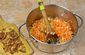 Į puodą, kuriame kepė šoninė, sudėkite paruoštus svogūnus, česnaką ir morkas, kepinkite, kol suminkštės. Nusausintą šoninę susmulkinkite ...