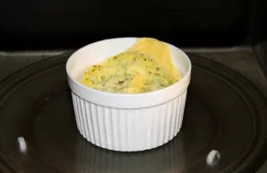 Cukinijų omletą įdėkite į mikrobangų krosnelę ir kepkite 800 W galioje 3 minutes. Iš karto patiekite gatavą omletą.