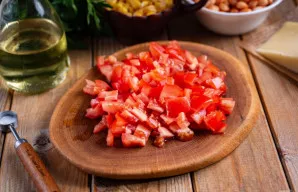 Šviežius pomidorus supjaustykite mažais kubeliais.