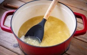 Tada supilkite sausą vyną, sultinį, įberkite druskos, užvirinkite ir troškinkite ant silpnos ugnies 15 minučių.