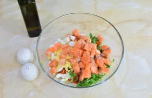 Žuvį supjaustykite mažais kubeliais. Pagardinkite salotas alyvuogių aliejumi, druska ir prieskoniais pagal skonį. Išmaišykite.