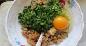 Kai vištiena atvės, į ją įdėkite laiškinį svogūną ir žalią kiaušinį. Gerai išmaišykite.