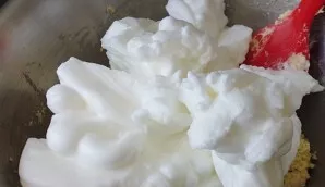Kiaušinių baltymus išplakite sausame dubenyje iki standžių putų ir atsargiai įmaišykite į tešlą.